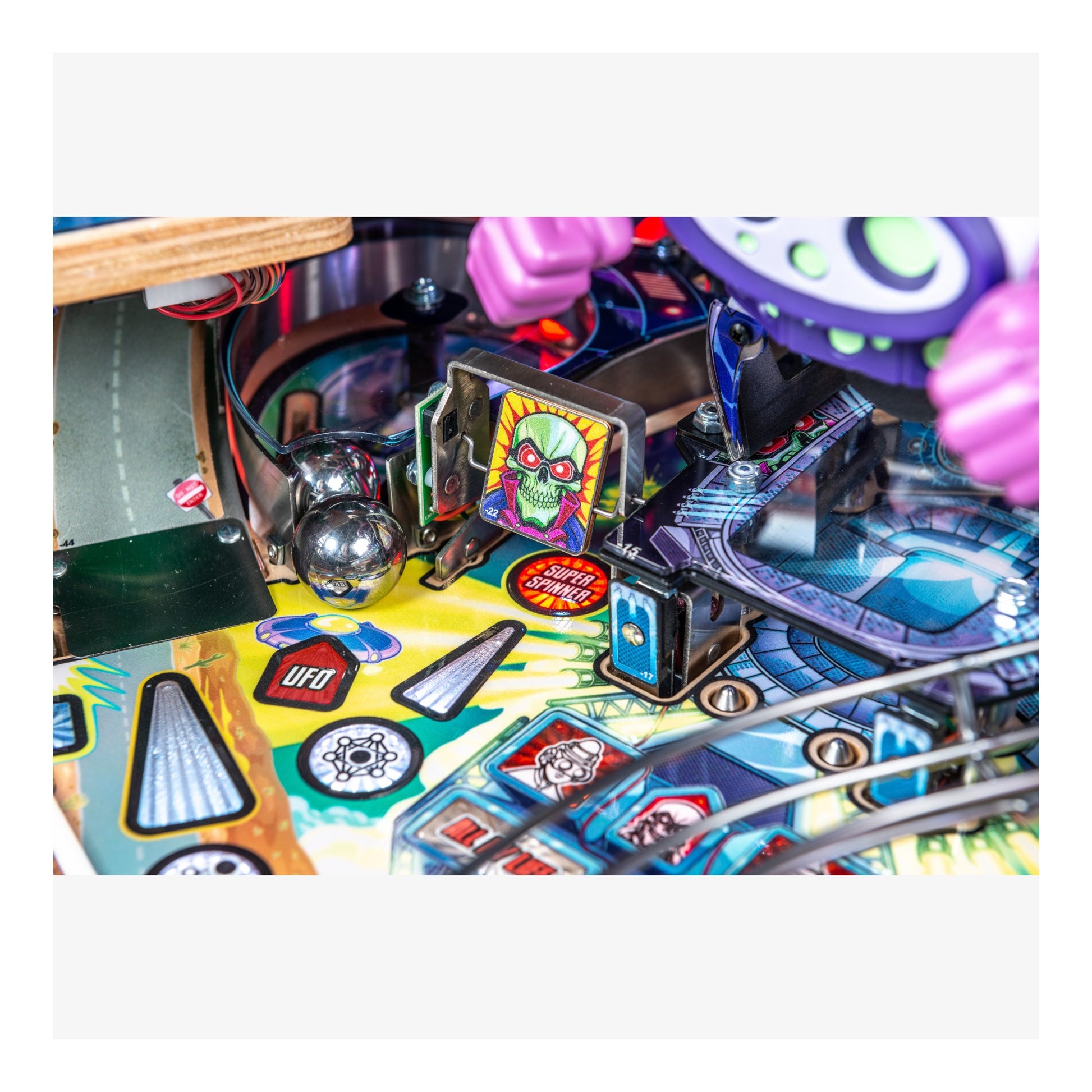 Close-up of a pinball machine with colorful design and various components.