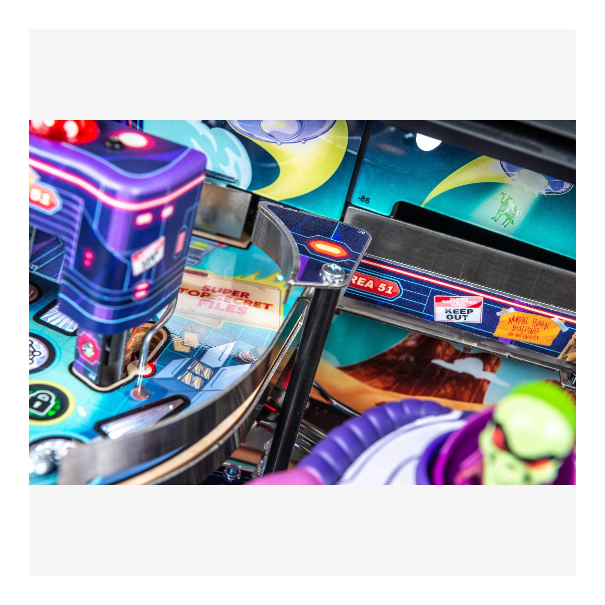 Close-up of a colorful pinball machine with vibrant graphics and neon lights.