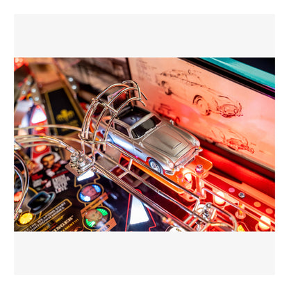 Close-up of a pinball machine with a car figure and colorful playfield.