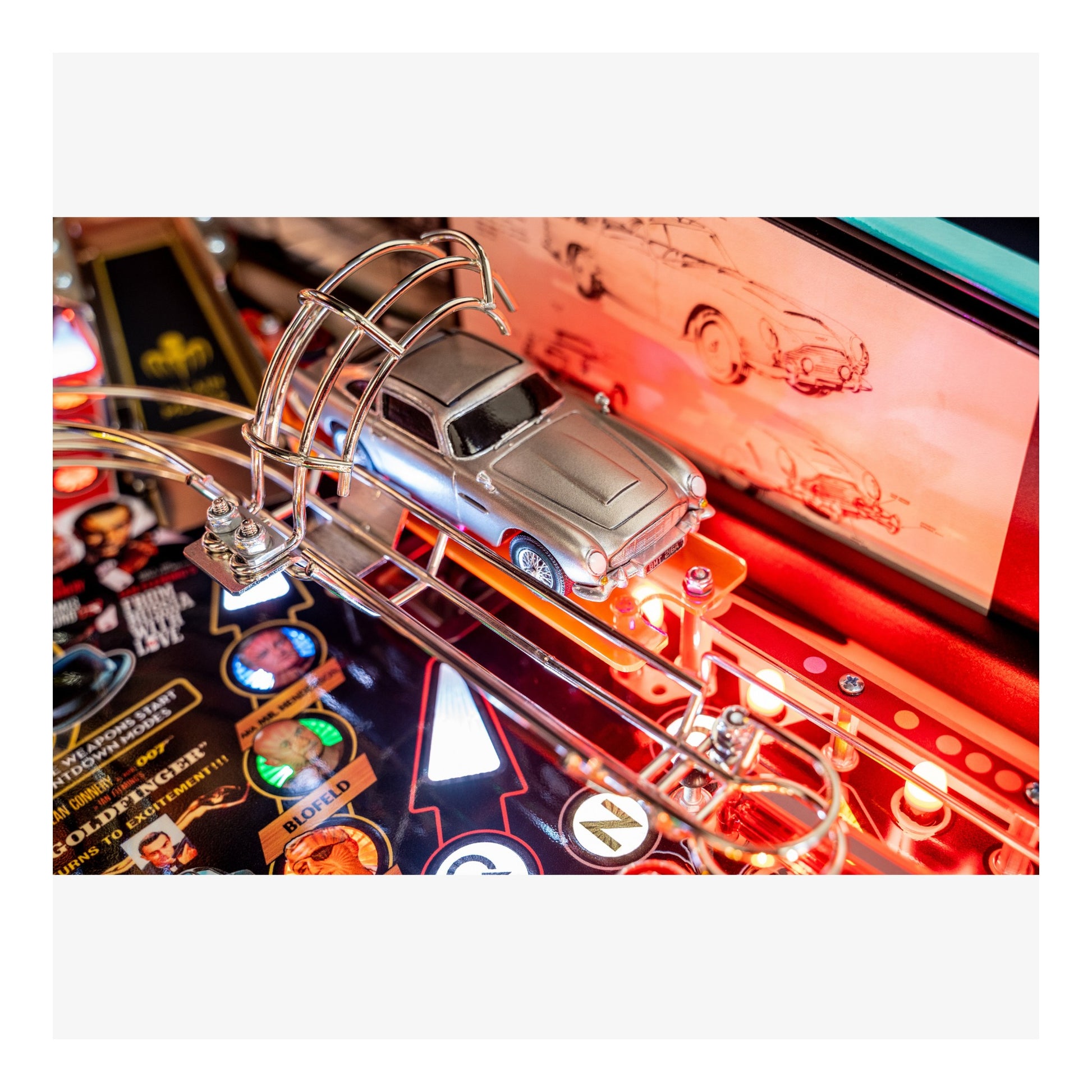 Close-up of a pinball machine with a car figure and colorful playfield