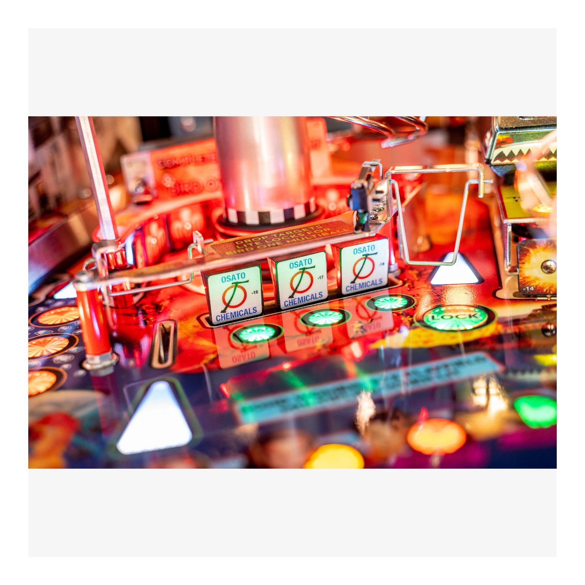 Close-up of a colorful pinball machine with various components and lights.