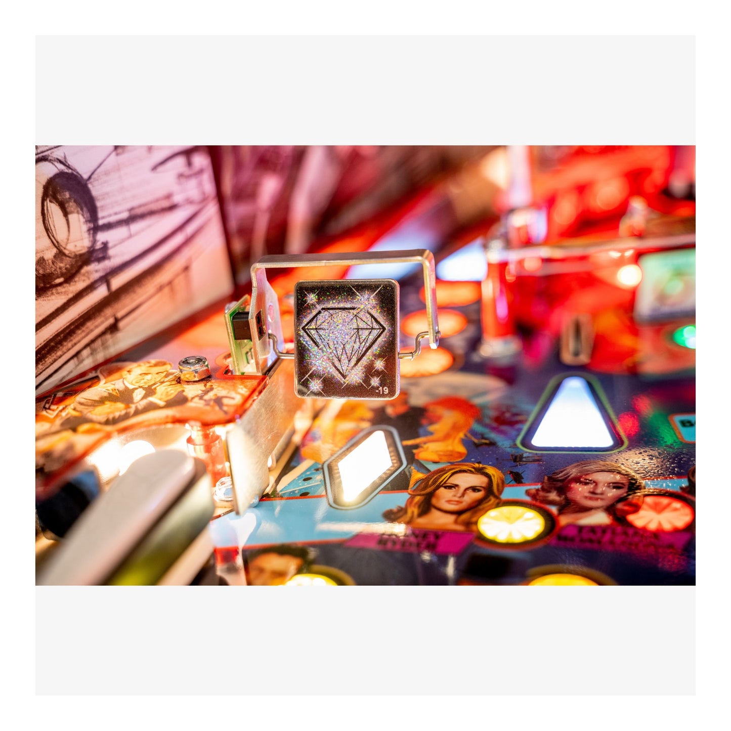 Close-up of a pinball machine with colorful artwork and lights.