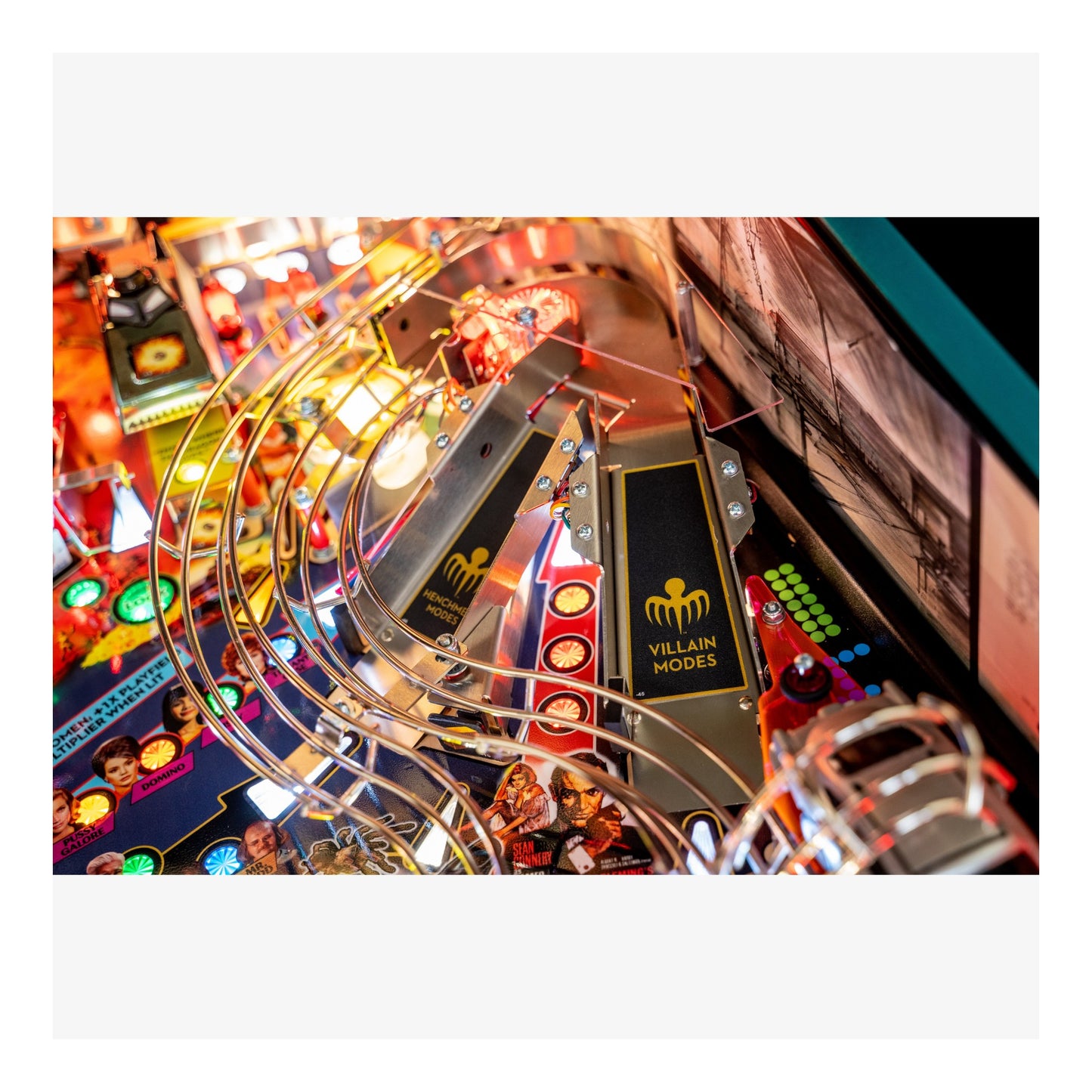 Close-up of a pinball machine with 'Villain Modes' component and colorful playfield.