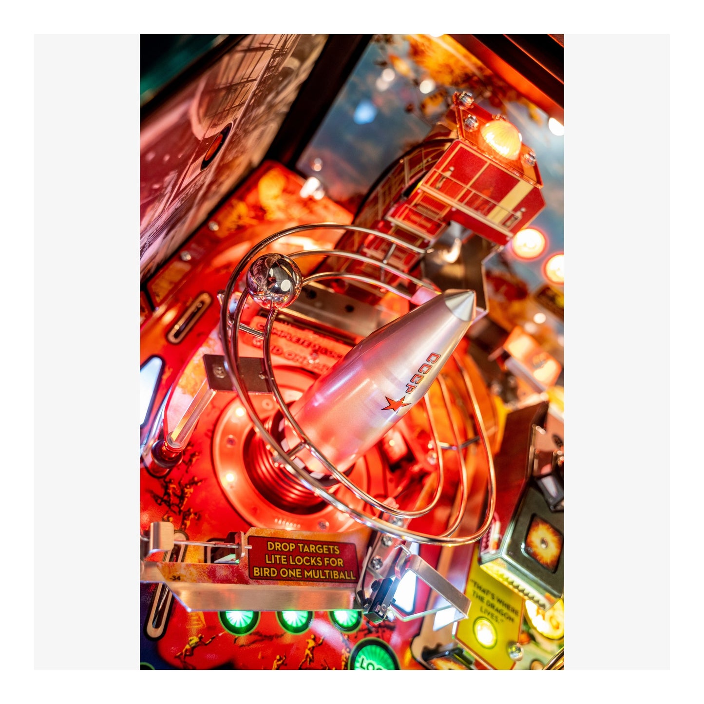 Close-up of a vintage pinball machine with bright lights and mechanical components.