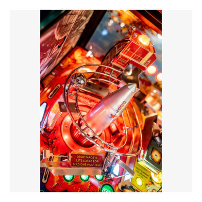 Close-up of a vintage pinball machine with bright lights and mechanical components.
