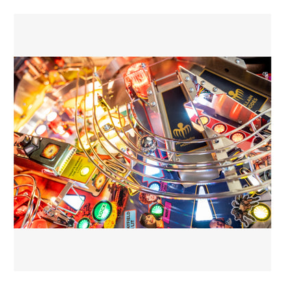 Close-up of a colorful pinball machine with various lights and details.