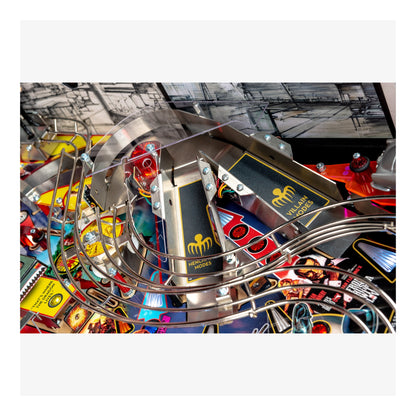 Close-up of a pinball machine with colorful playfield and metal components.