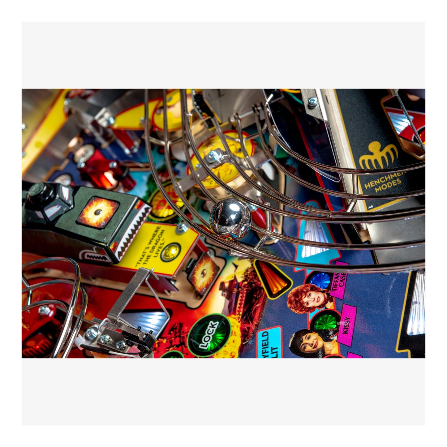 Close-up of a pinball machine with colorful artwork and metal components.
