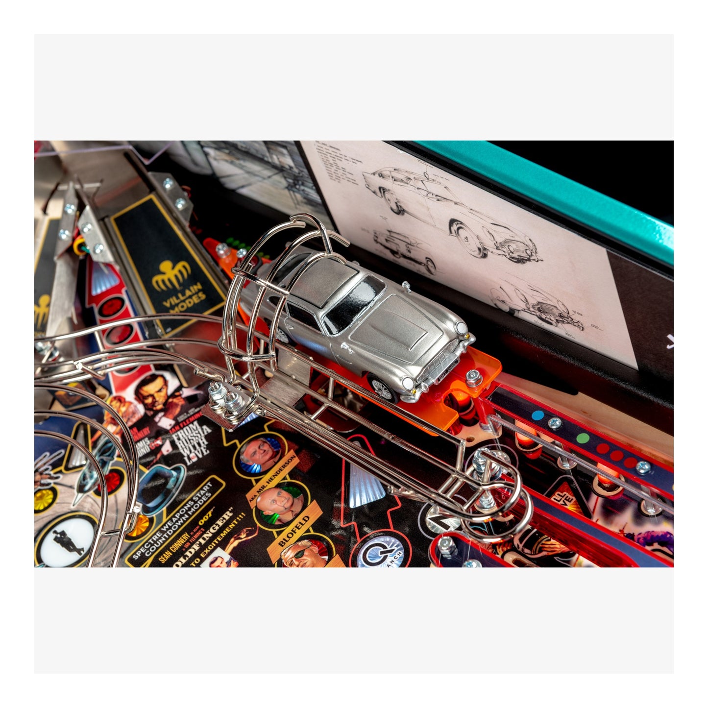 Close-up of a pinball machine with a toy car on the track