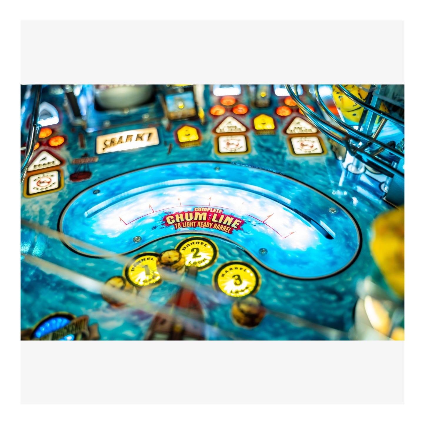 Close-up of a pinball machine with colorful playfield and various buttons.