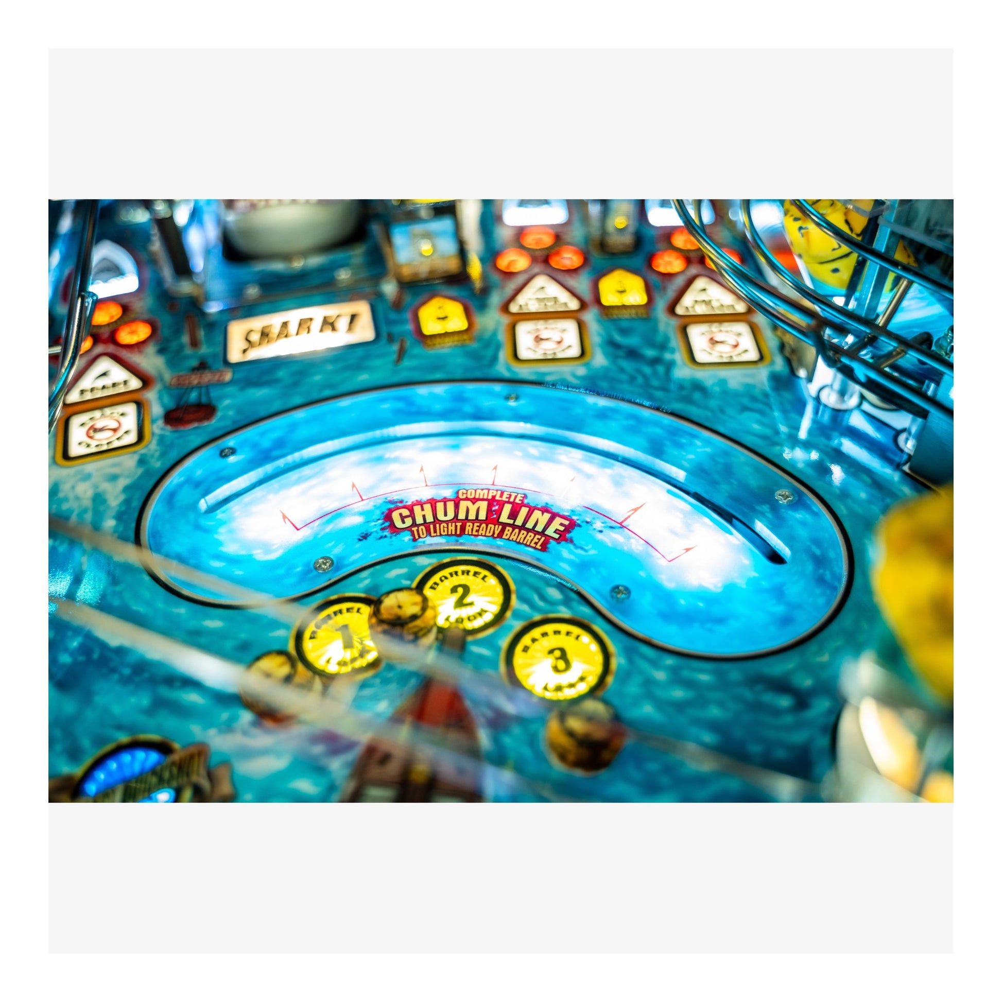 Close-up of a pinball machine with colorful playfield and various buttons.