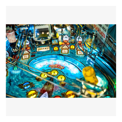 Close-up of a pinball machine with various lights and symbols.