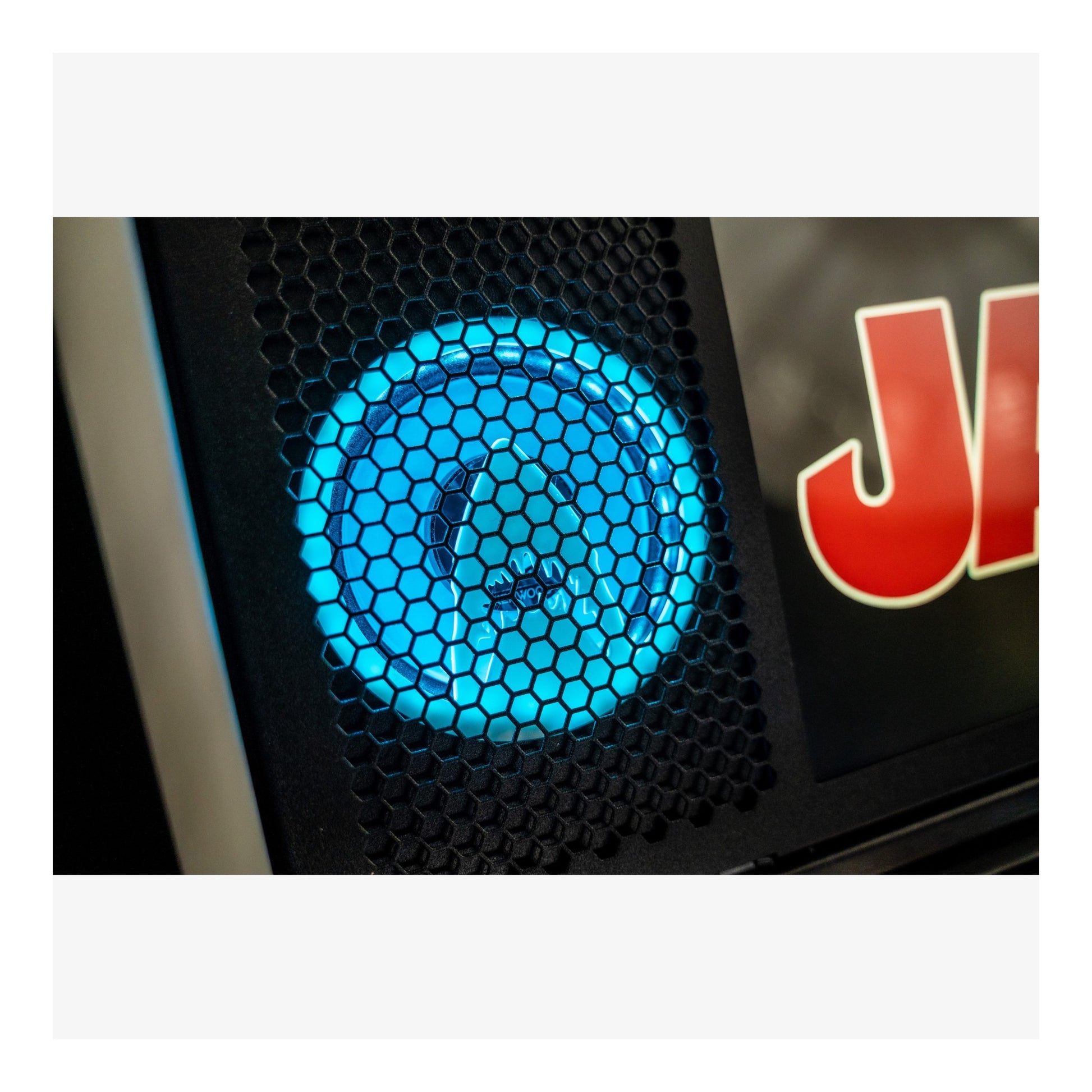 Close-up of a car grille with a blue light and 'JL' logo.