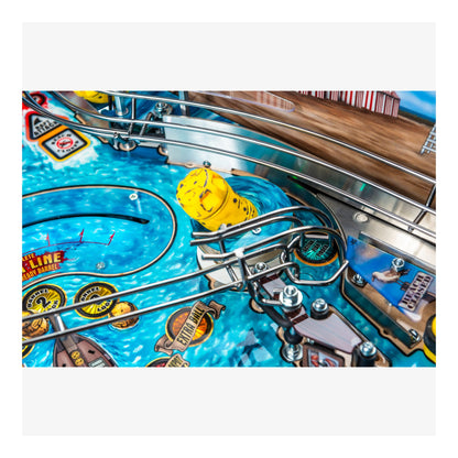 Close-up of a pinball machine with a yellow ball on a blue playing field.
