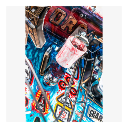 Close-up of a colorful pinball machine with various components and branding.
