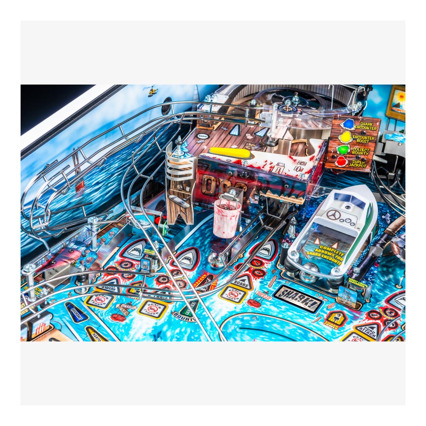 Close-up of a pinball machine with various components and a car figure on a white background