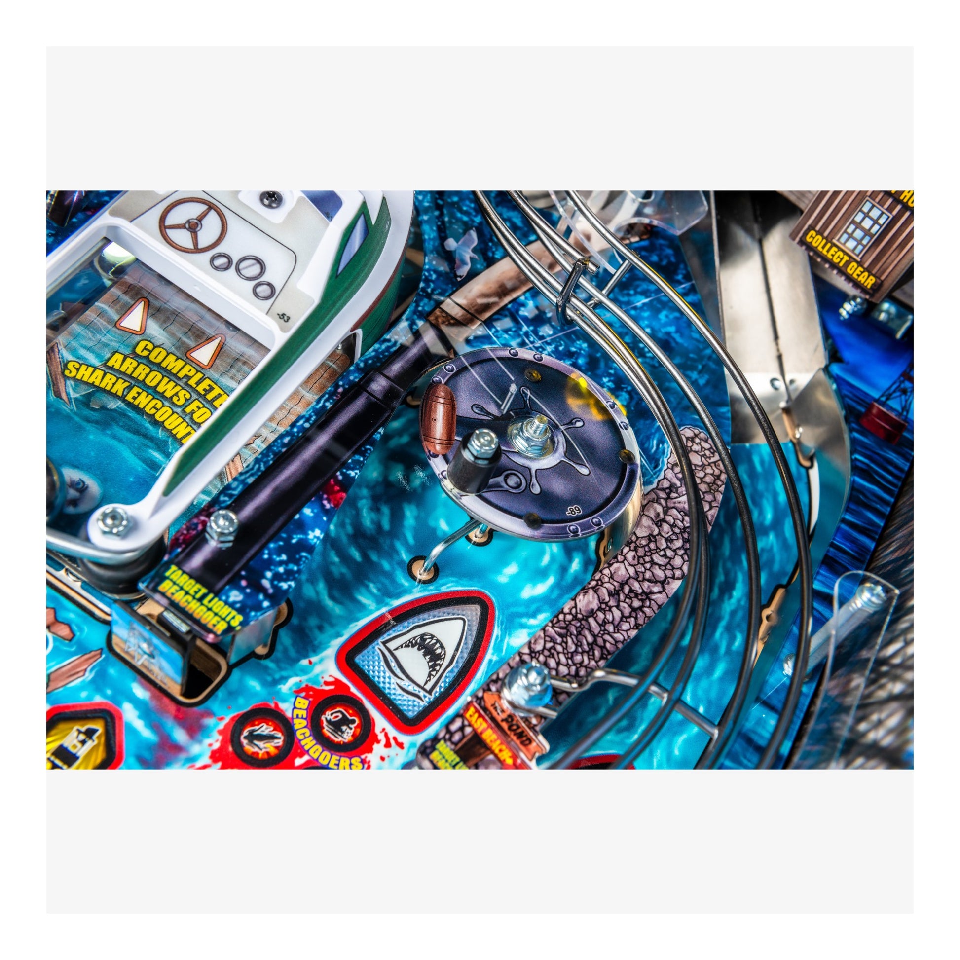 Close-up of a pinball machine with colorful design and various components.