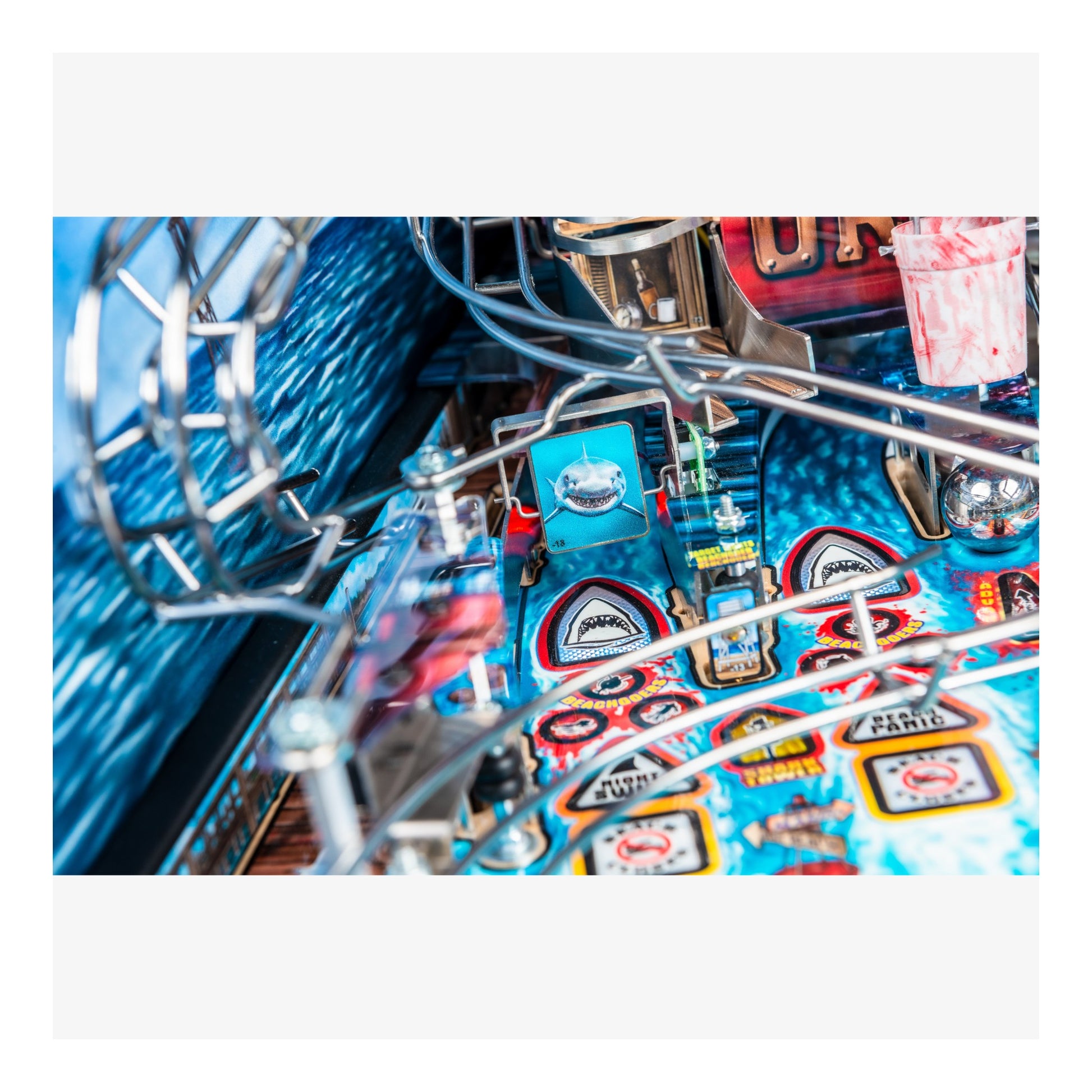 Close-up of a pinball machine with colorful designs and metal components.