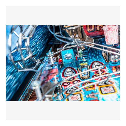 Close-up of a pinball machine with colorful designs and metal components.