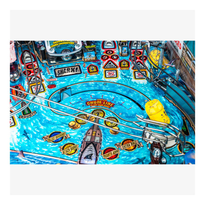 Close-up of a pinball machine with shark-themed design and various game elements.