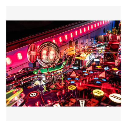 Close-up of a pinball machine with vibrant neon lights and colorful playfield.