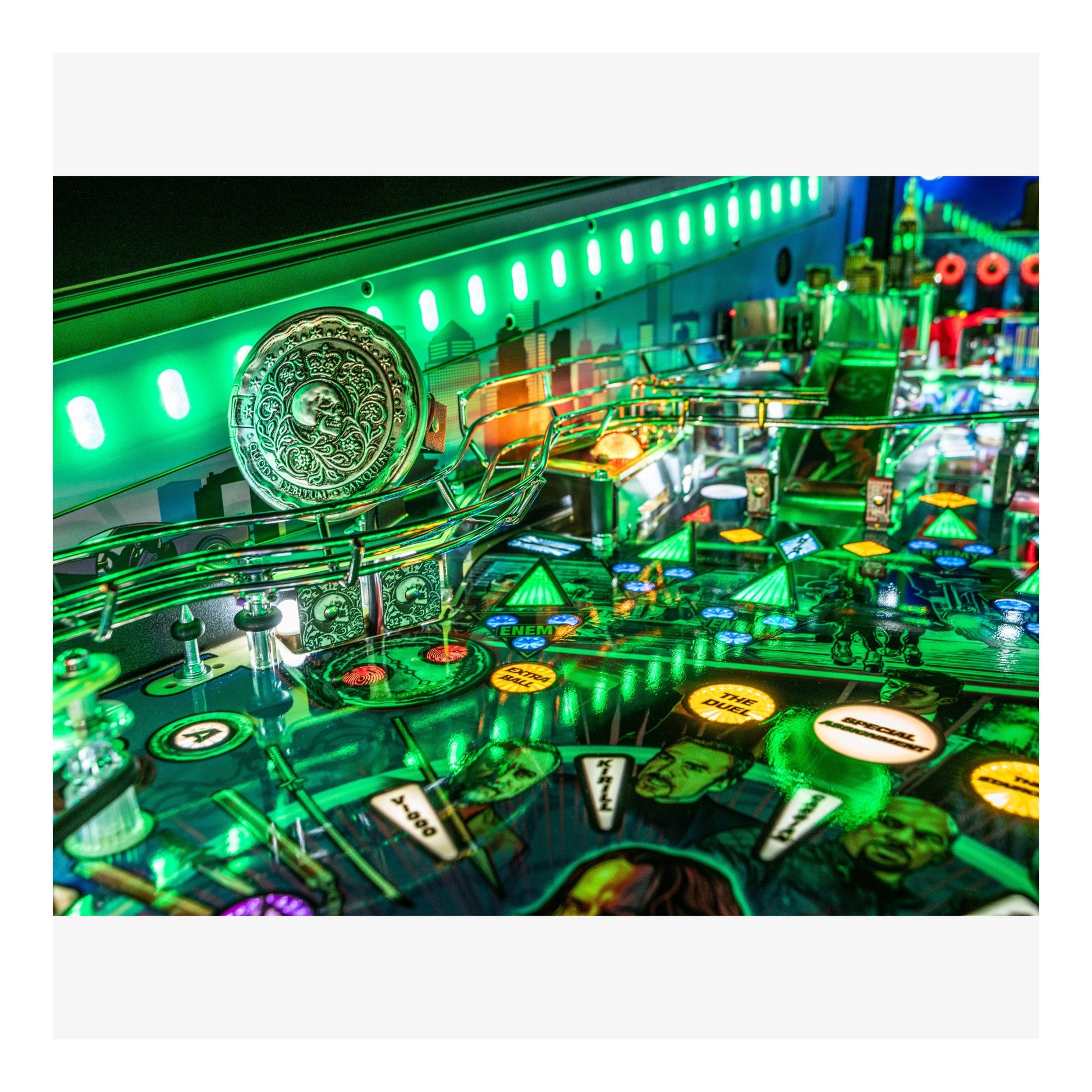 Close-up of a pinball machine with vibrant green lighting and various playing components.