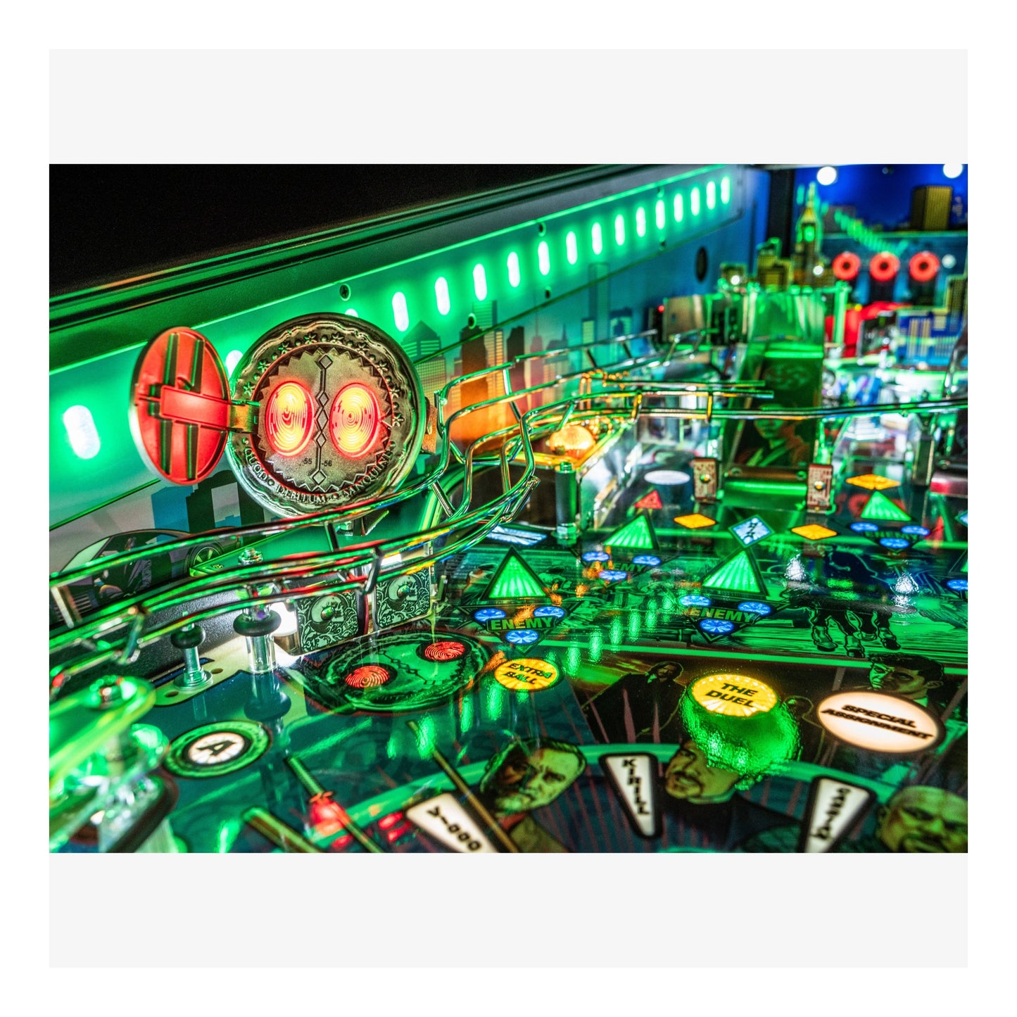 Close-up of a pinball machine with vibrant green and red lights.