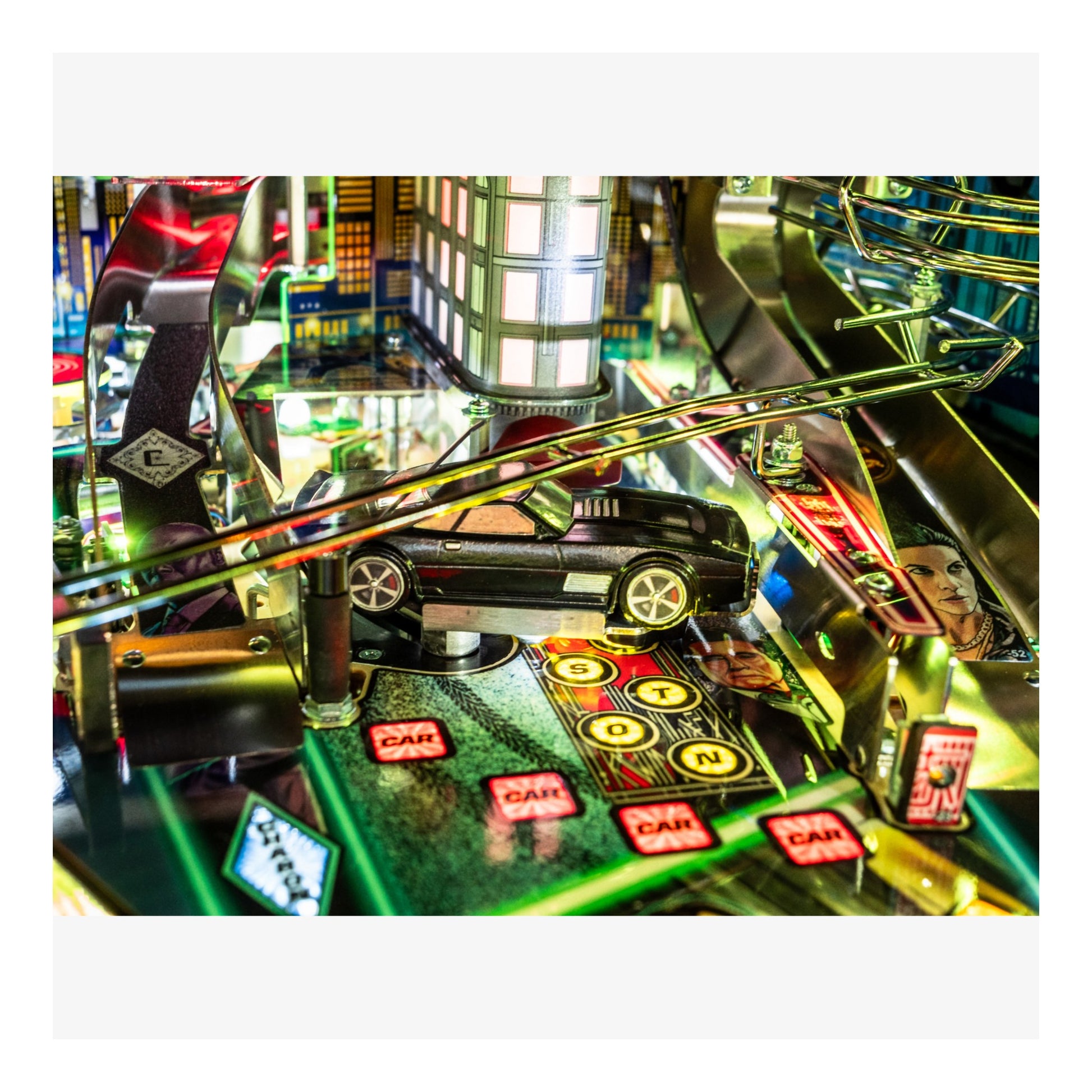 Toy car on a pinball machine with colorful lights and reflections