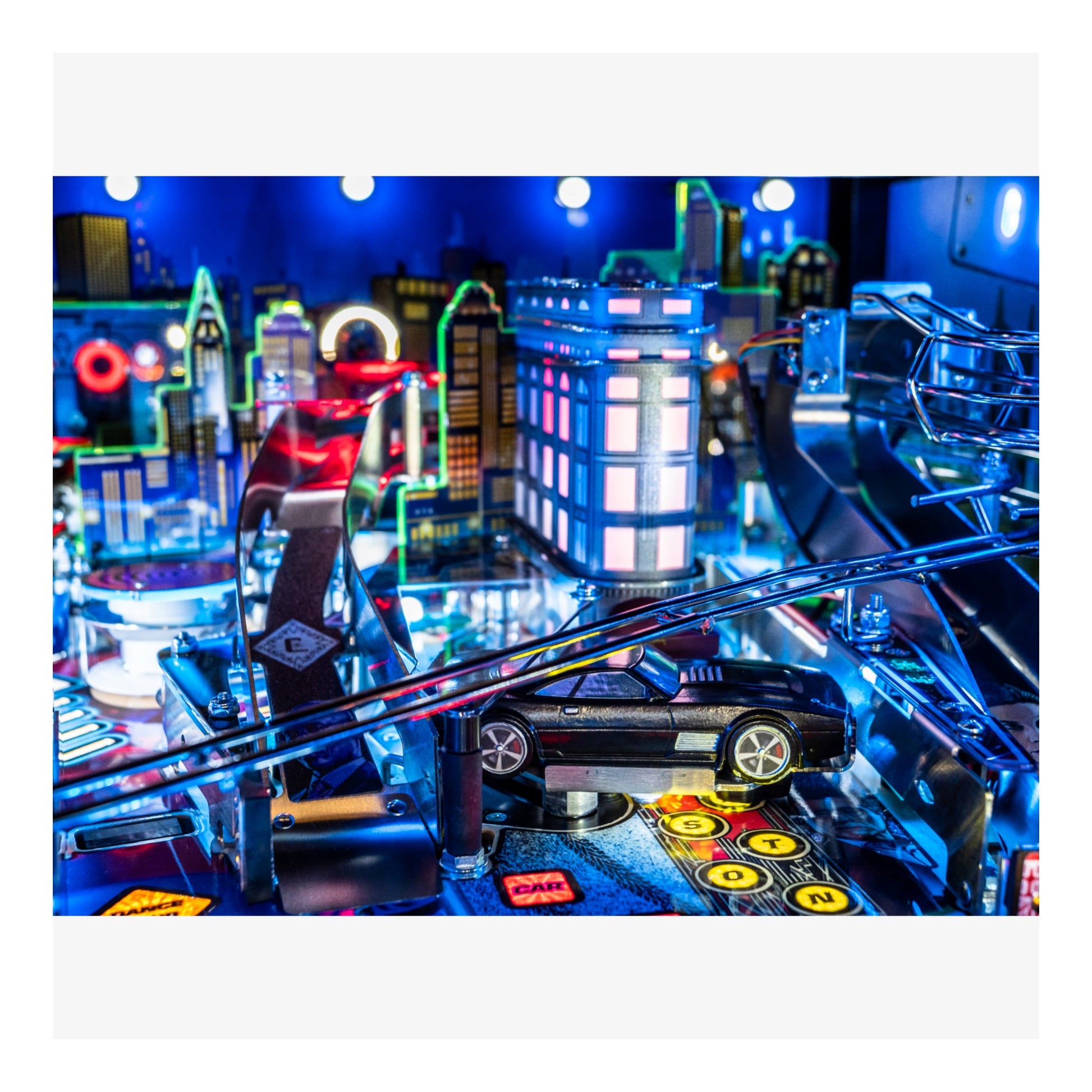 Close-up of a pinball machine with vibrant neon lights and a cityscape background.