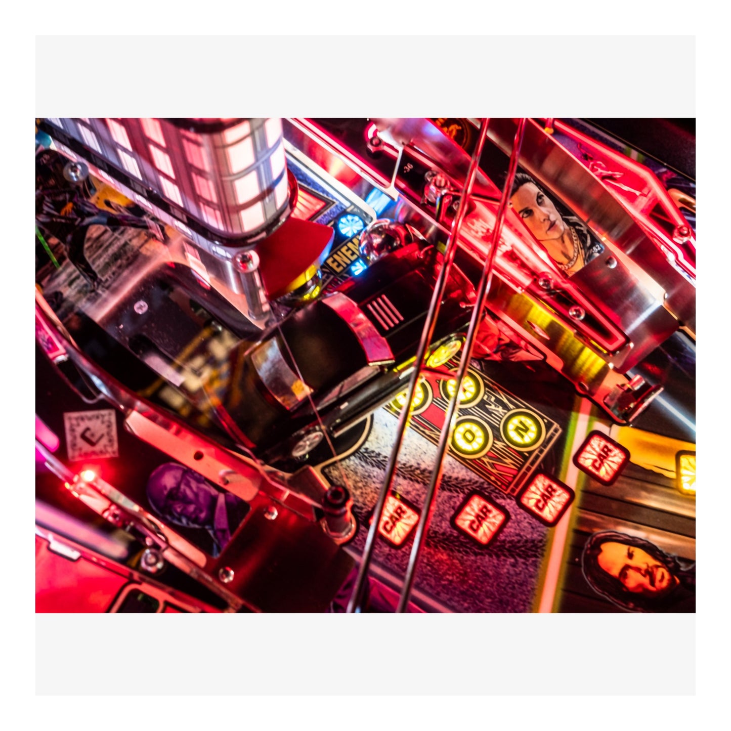 Close-up of a pinball machine with neon lights and mechanical components.