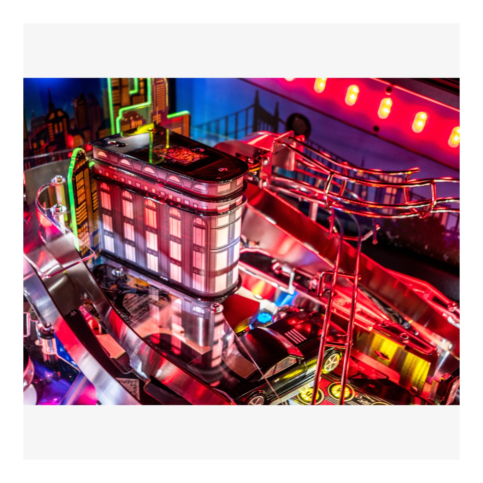 Close-up of a pinball machine with vibrant neon lights and reflections.