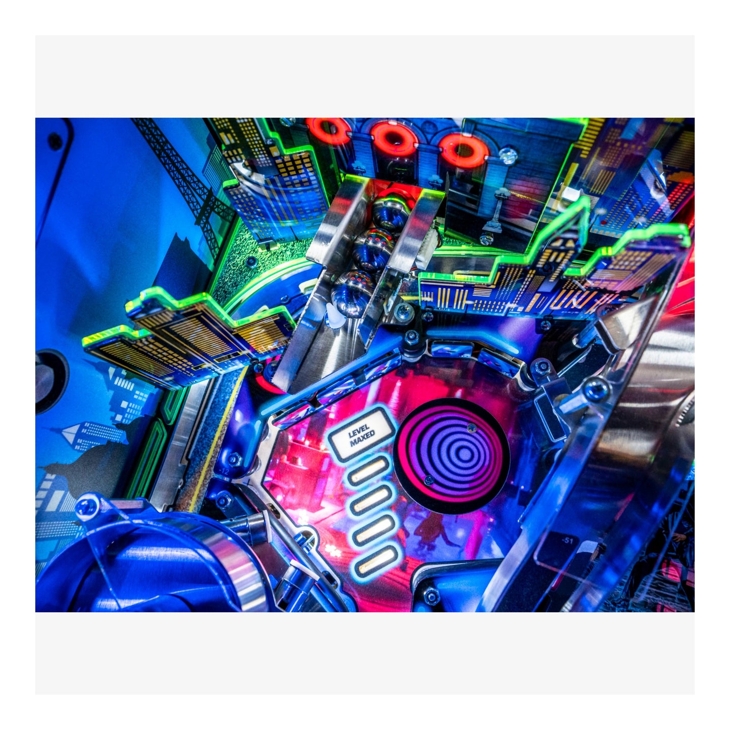 Close-up of a colorful pinball machine with vibrant lights and mechanical components.