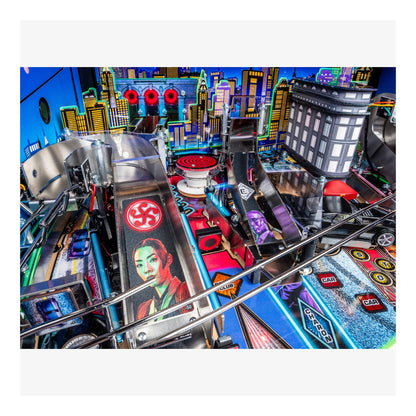 Close-up of a pinball machine with colorful playfield and vibrant cityscape background