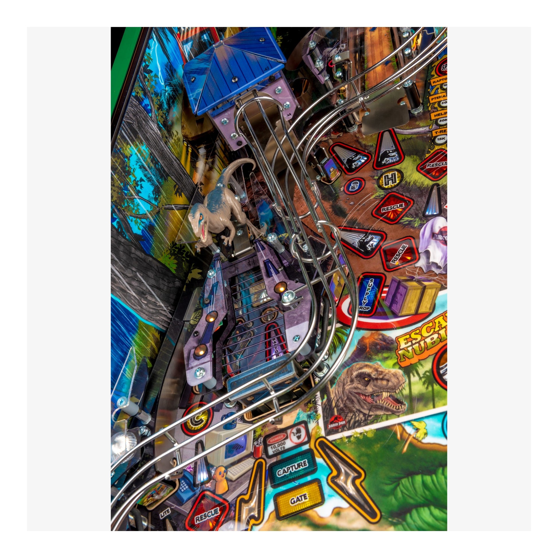 Close-up of a pinball machine with various elements and a dinosaur figure.