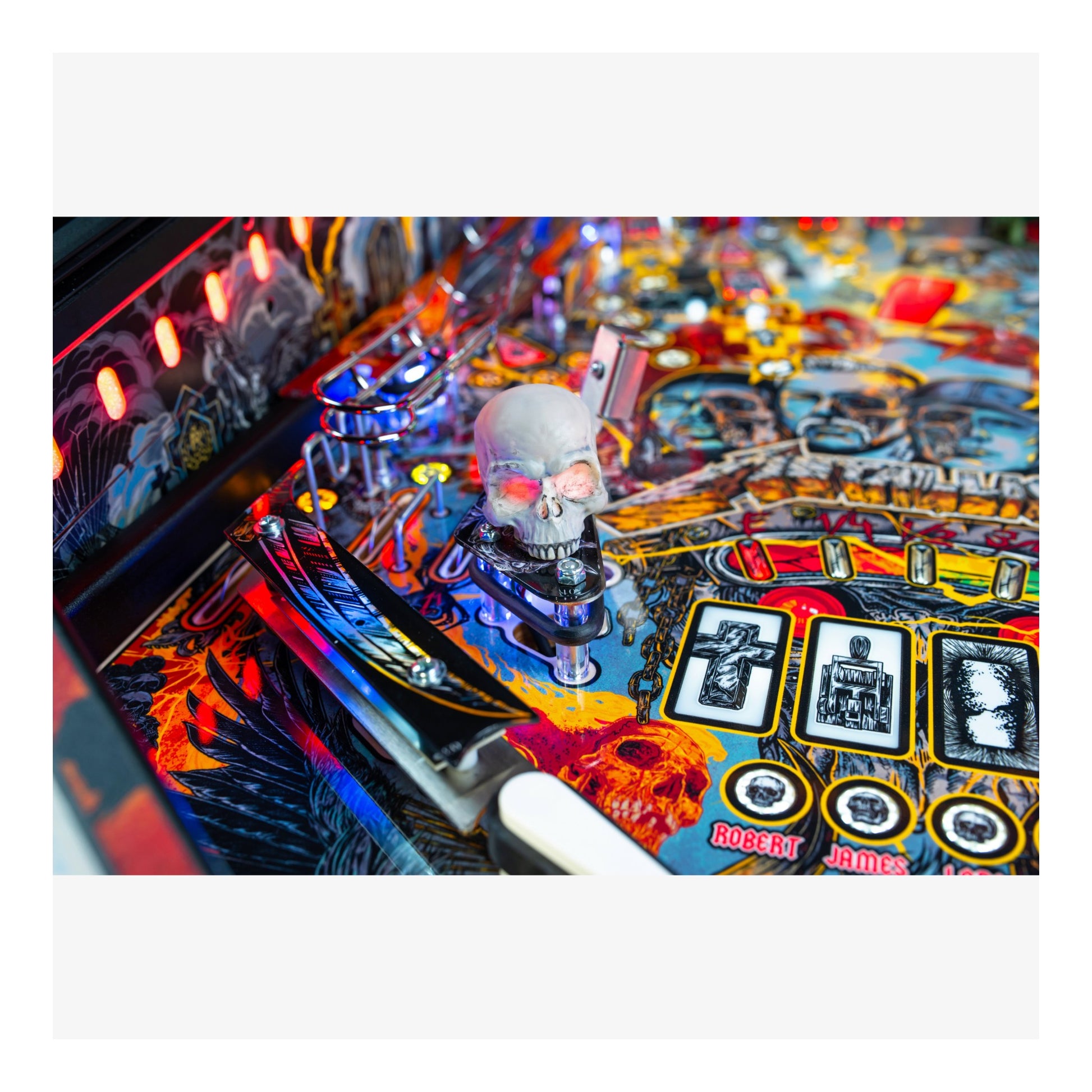 Close-up of a colorful pinball machine with a skull figure and various lights.