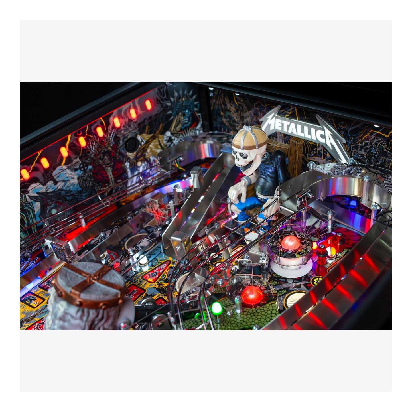 Close-up of a pinball machine with 'Metallica' branding and colorful lights.