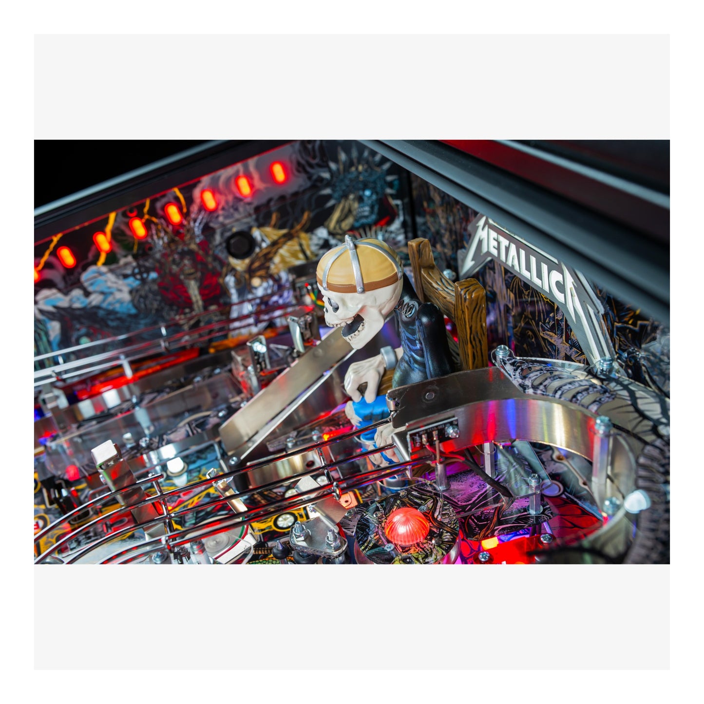 Close-up of a pinball machine with 'Metallica' branding and various components.