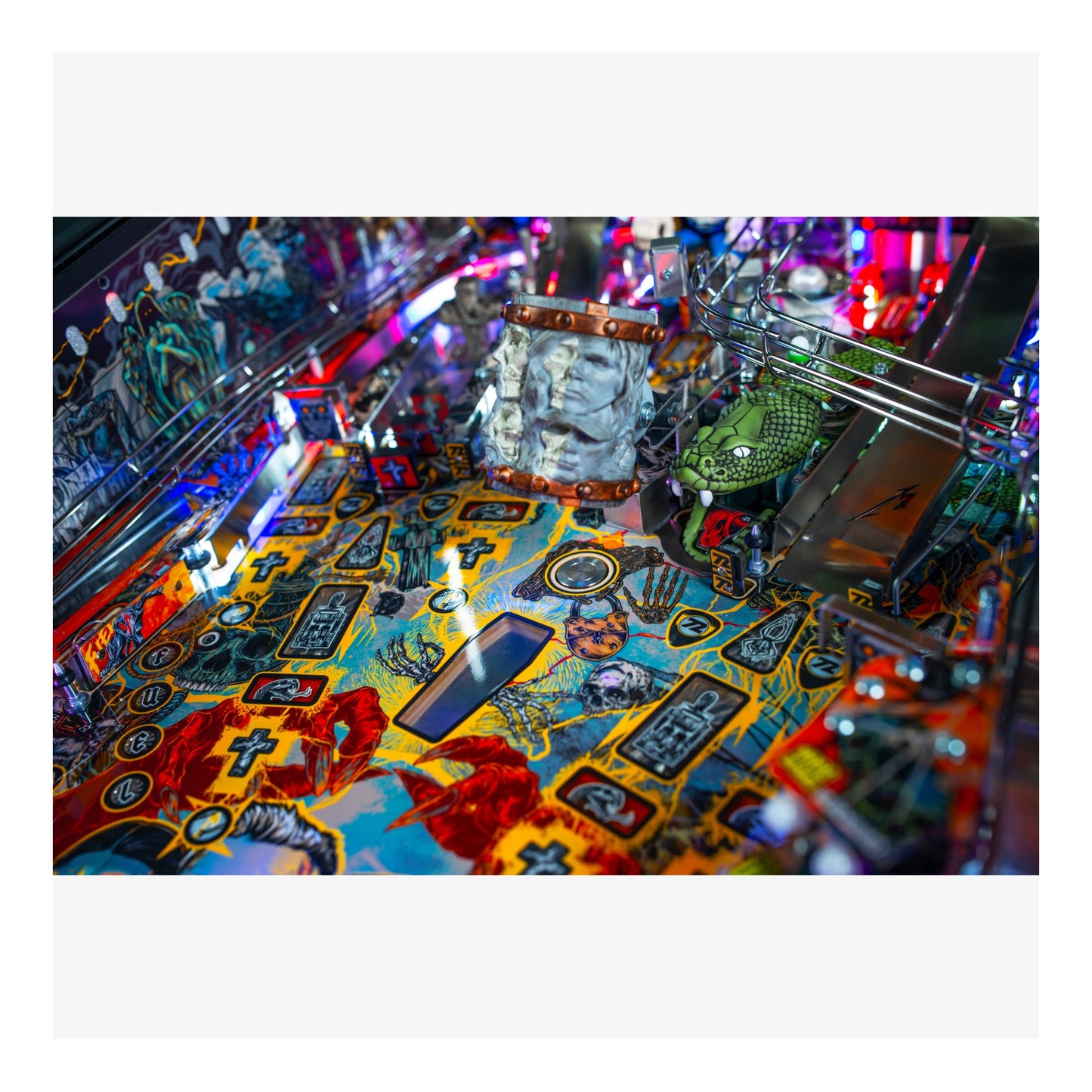 Close-up of a colorful pinball machine with various elements and lights.