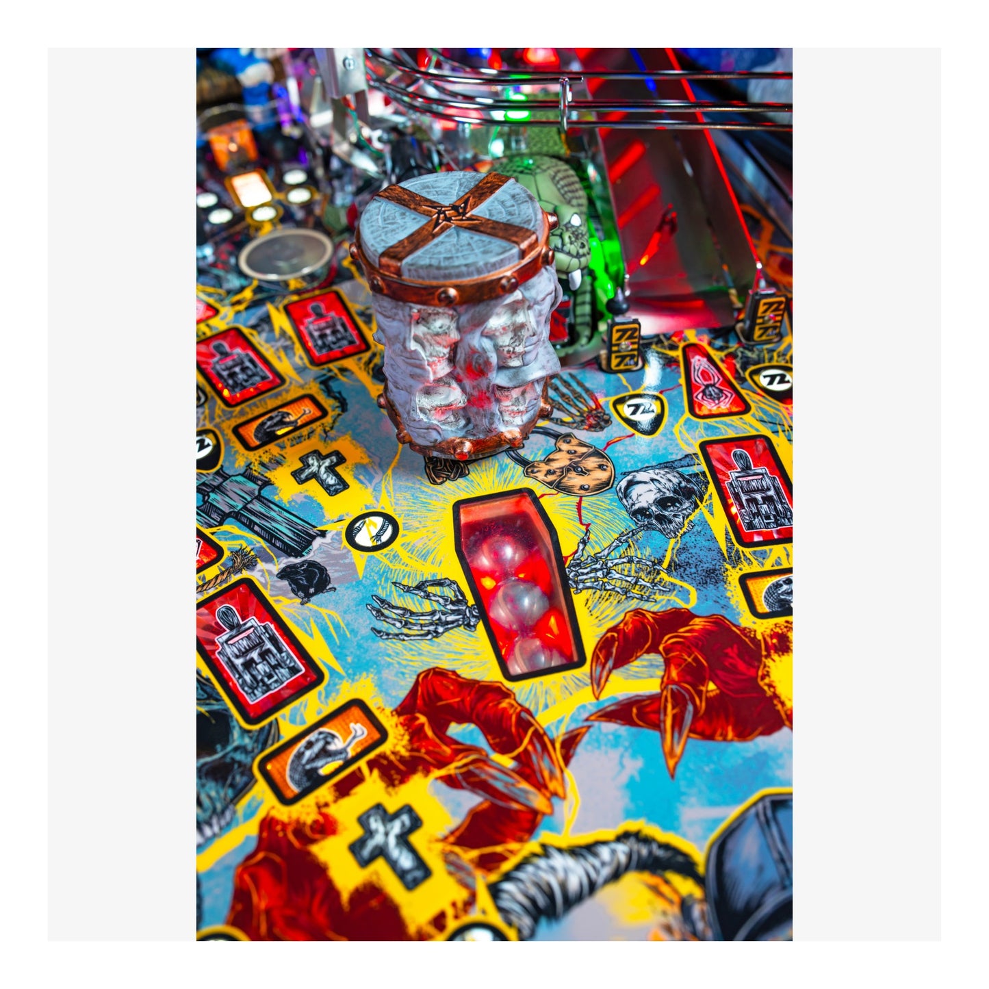 Close-up of a colorful pinball machine playing field with various symbols and graphics.