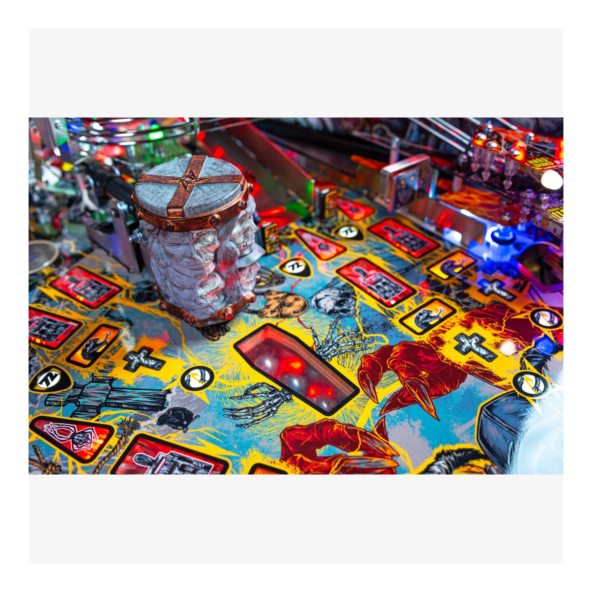 Close-up of a colorful pinball machine with various symbols and lights.