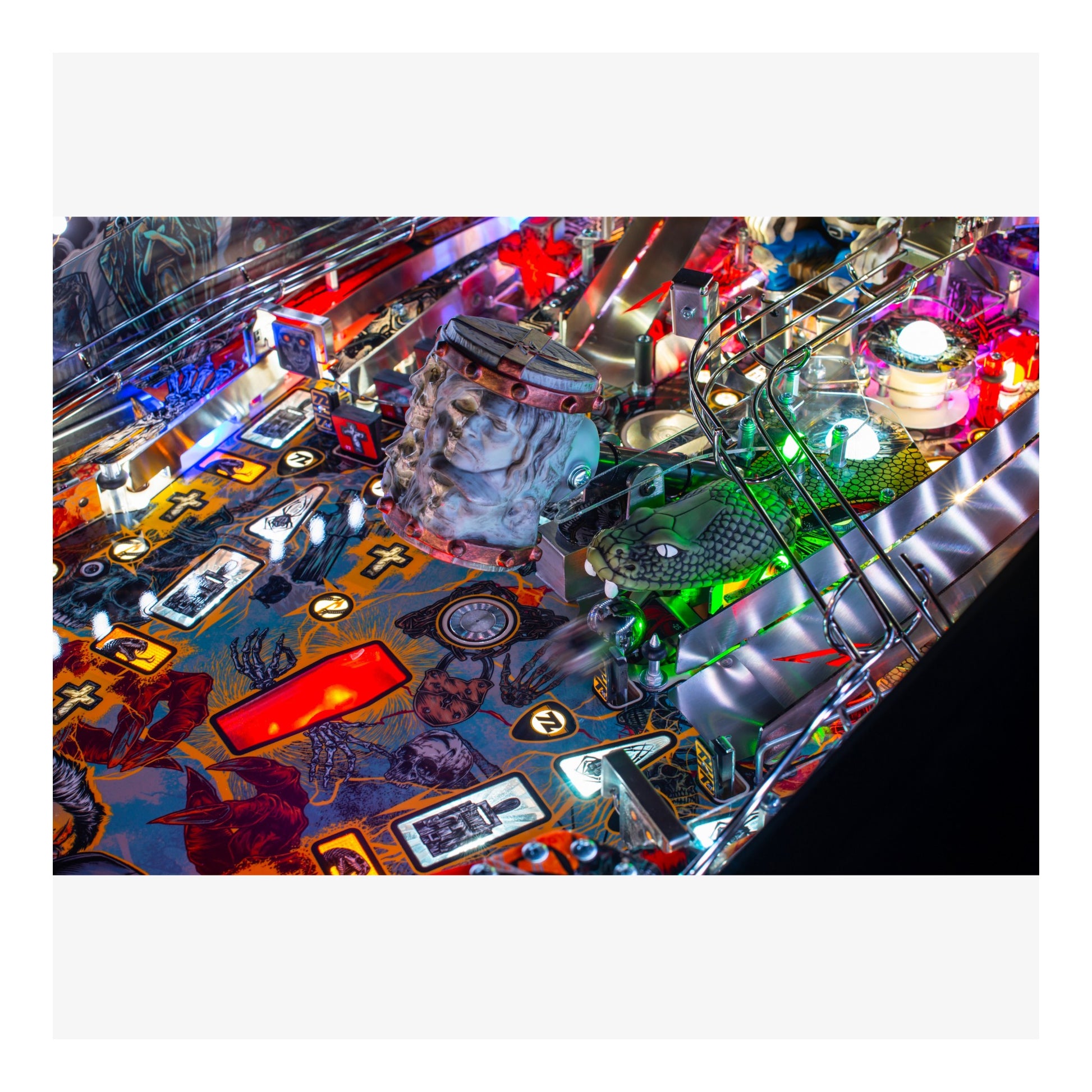 Close-up of a colorful pinball machine with various lights and players.