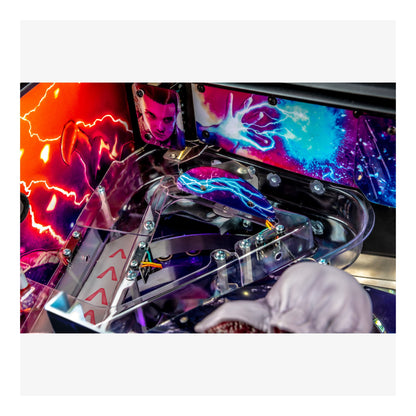 Close-up of a colorful pinball machine with vibrant graphics and a hand interacting with it.