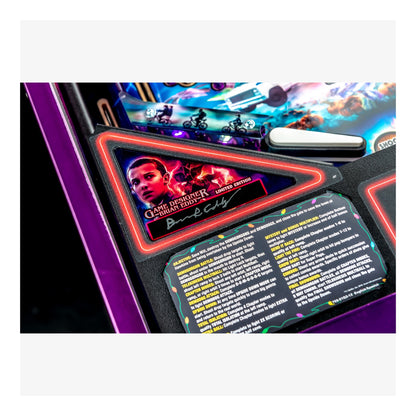 Close-up of a pinball machine with a player card and game details.