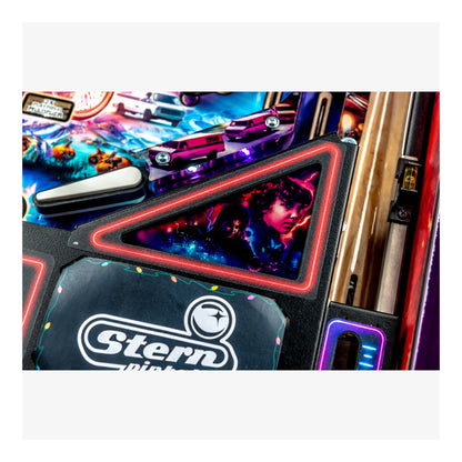 Close-up of a Stern pinball machine with colorful design and player portrait.