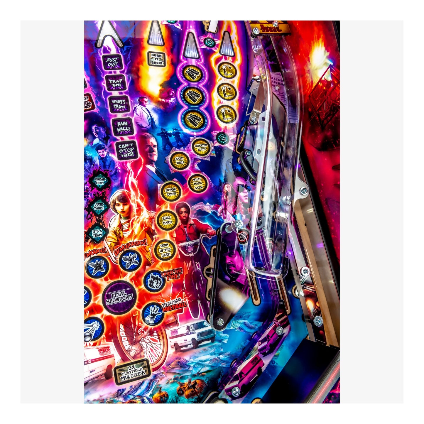 Close-up of a colorful pinball machine with various buttons and lights.