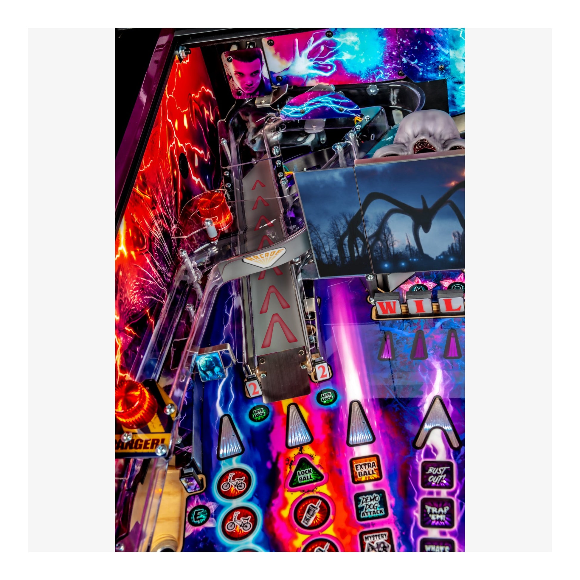 Close-up of a colorful pinball machine with various lights and symbols.