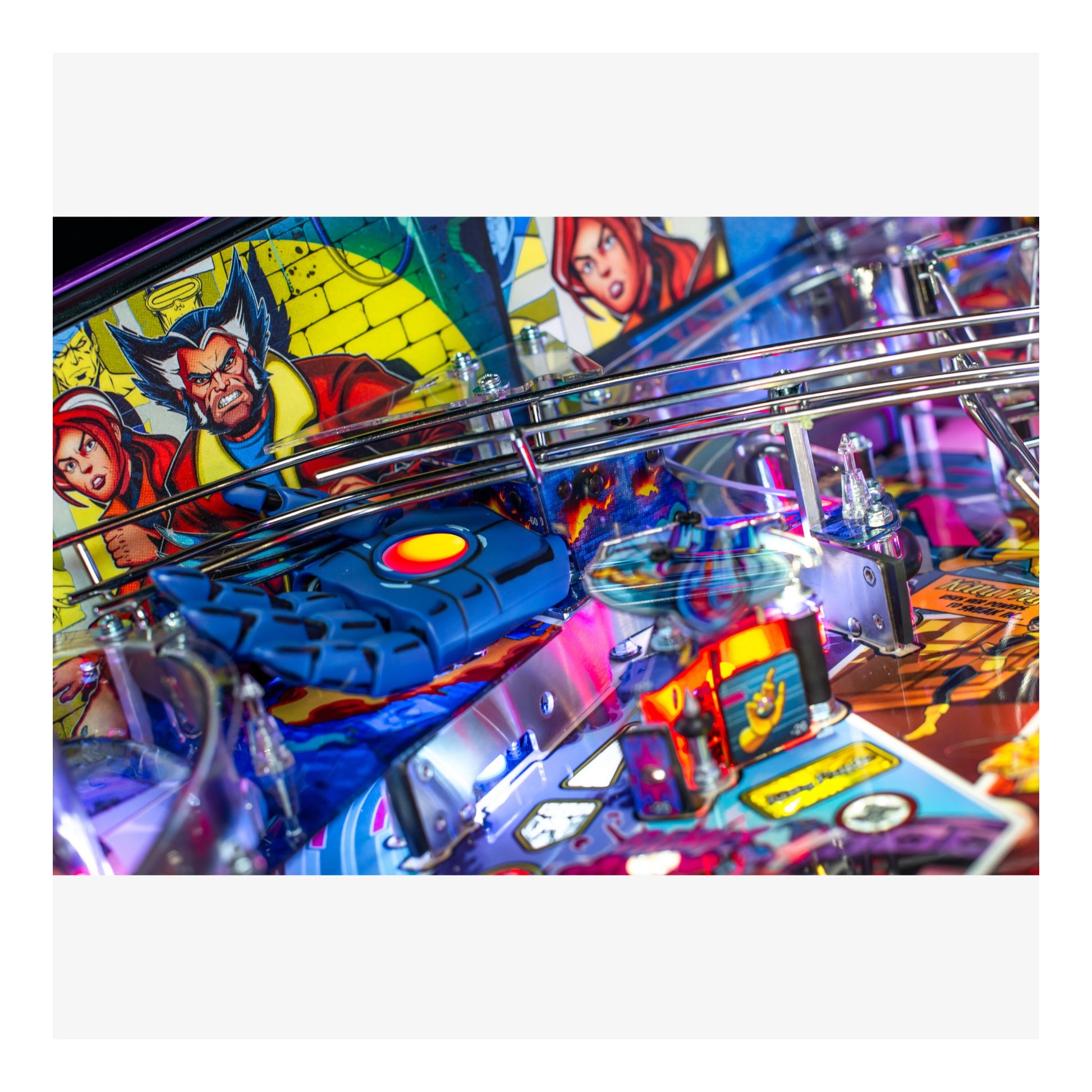 Close-up of a colorful pinball machine with superhero graphics