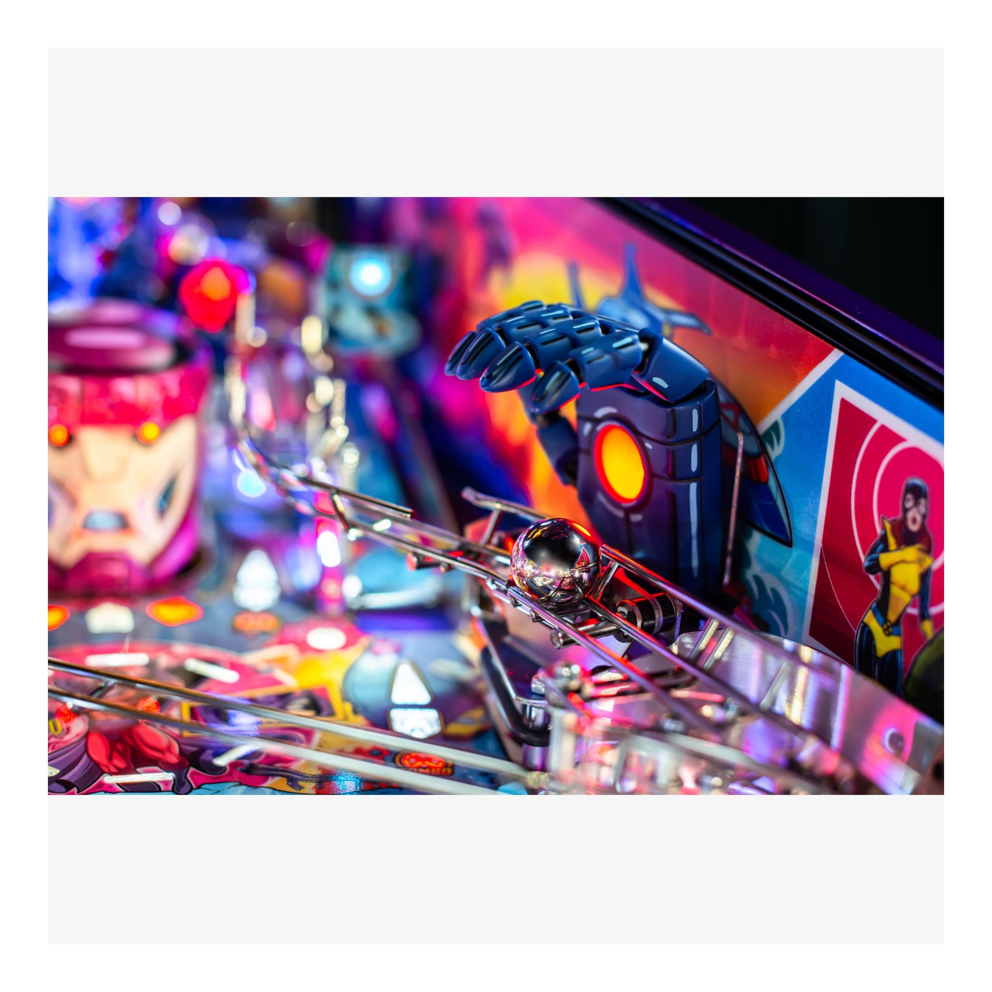 Close-up of a pinball machine with colorful design and robot figure.