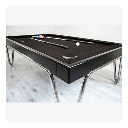 Black pool table with chrome legs on a light wooden floor.
