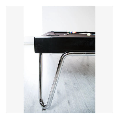 Black pool table with chrome legs on a white floor